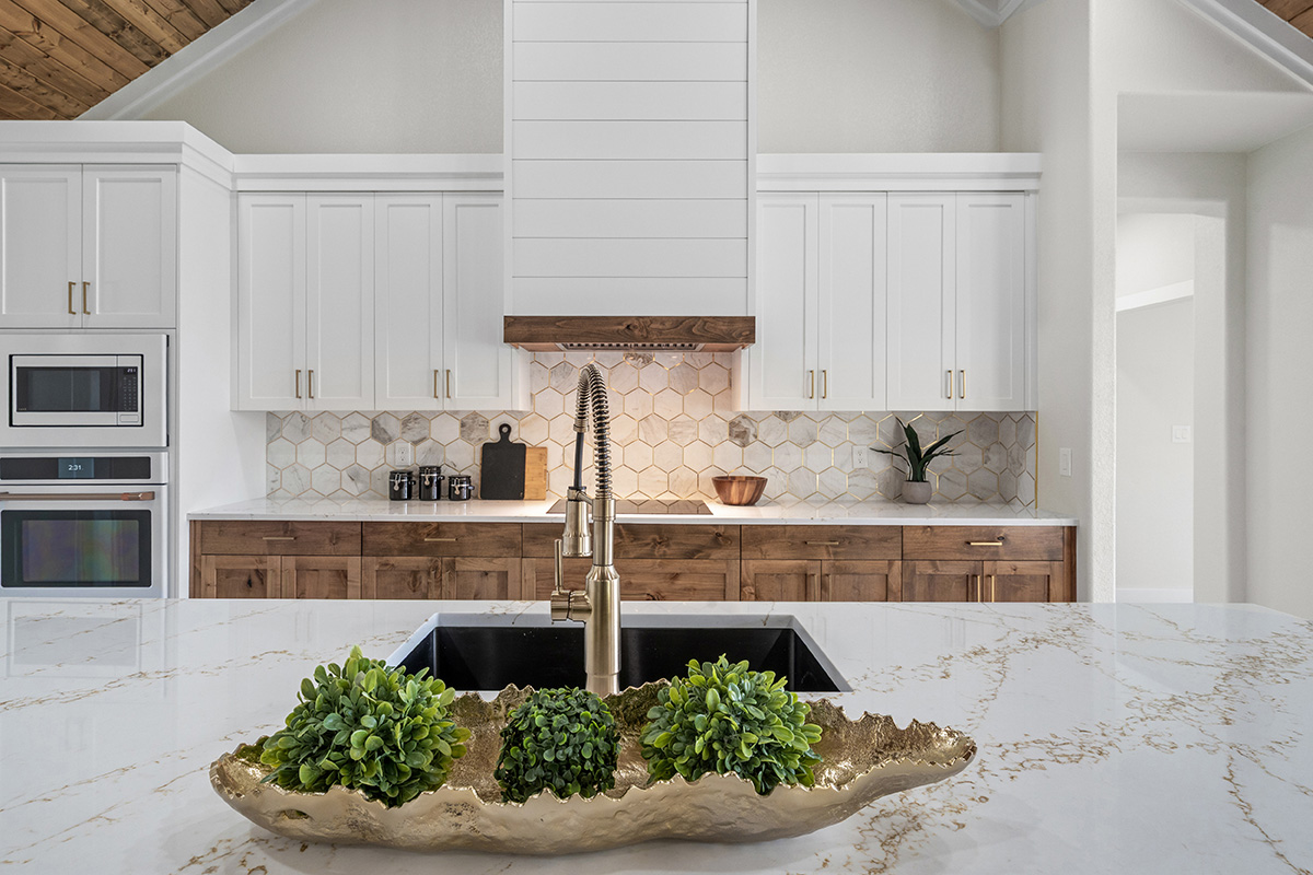 Quartz waterfall island with brass fixtures and hex backsplash