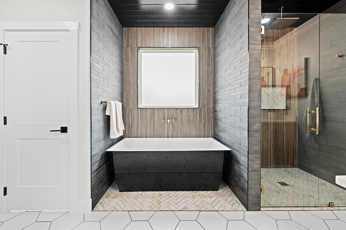 Primary bath with freestanding soaking tub and slat wood accent wall