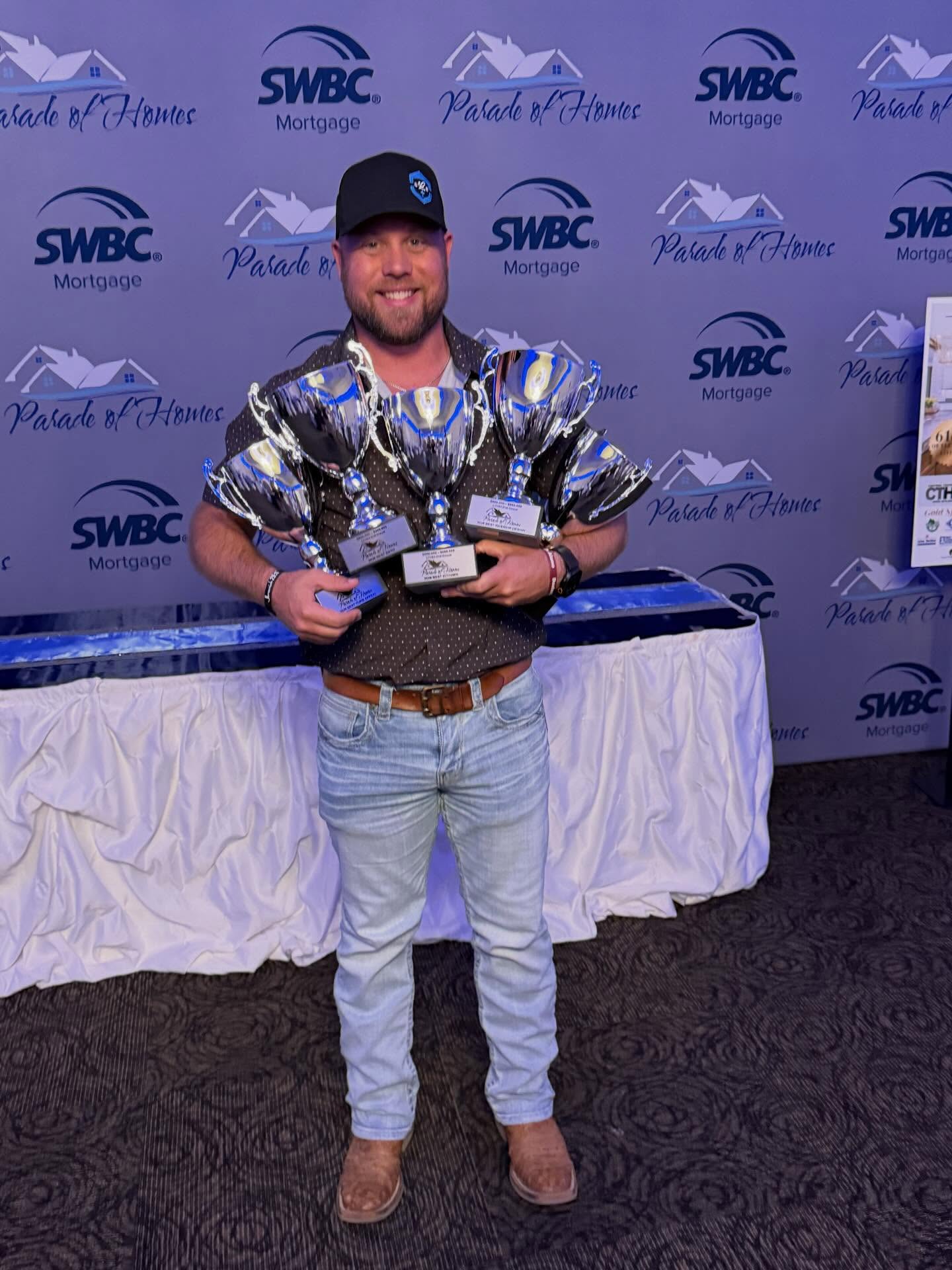 Jeremy Toms, owner and builder of Legacy Custom Builders, holding Parade of Homes award trophies