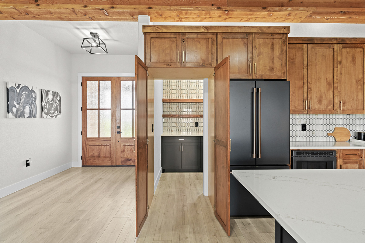 Butler's pantry with wood cabinetry and tile backsplash off the entry